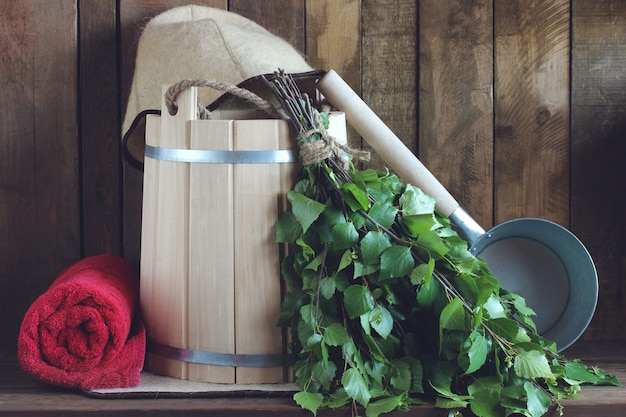 Birch broom, wooden bucket and bath towel.