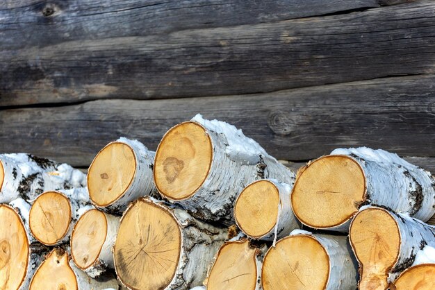 Birch churks are stacked Outdated fuel for home heating in winter Logs of firewood Rustic background with copy space