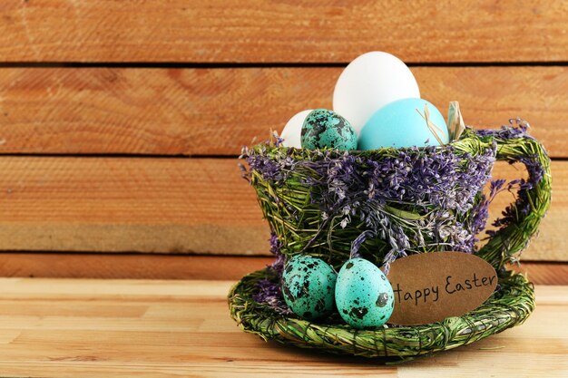 Bird colorful eggs in decorative mug on light background