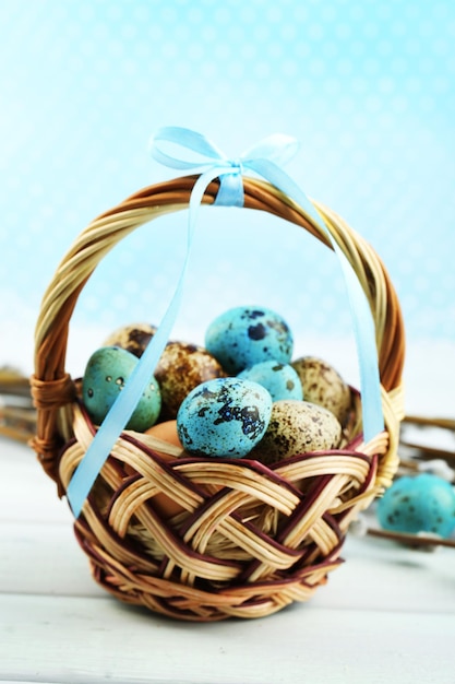 Bird eggs in wicker basket on bright background