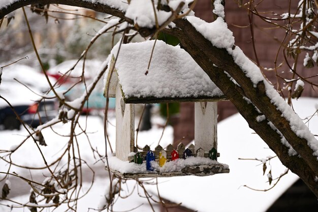 Photo bird feeder covered with snow against the background of the city landscape