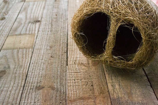 Bird nest is laid on a wooden background.