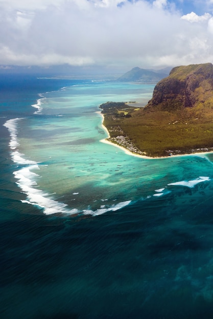 Вид с высоты птичьего полета на Ле Морн Брабант, объект всемирного наследия ЮНЕСКО. Коралловый риф острова Маврикий. Грозовое облако.