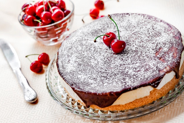 Bird's Milk souffle cake, bedekt met chocolade glazuur en versierd met rijpe sappige kersen