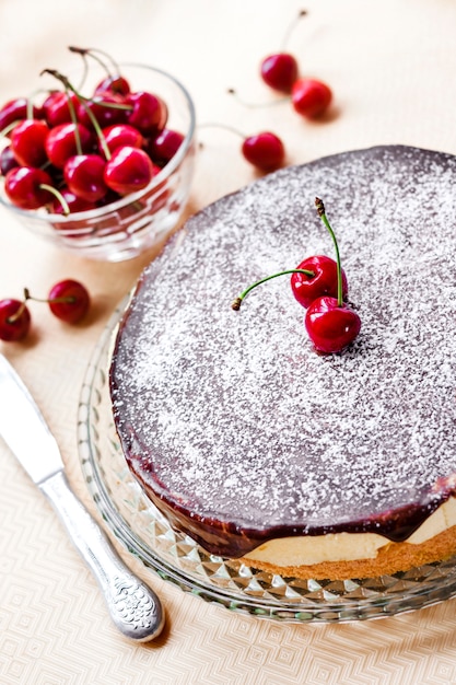 Bird's Milk-soufflécake, bedekt met chocoladeglans en versierd met rijpe sappige kersen