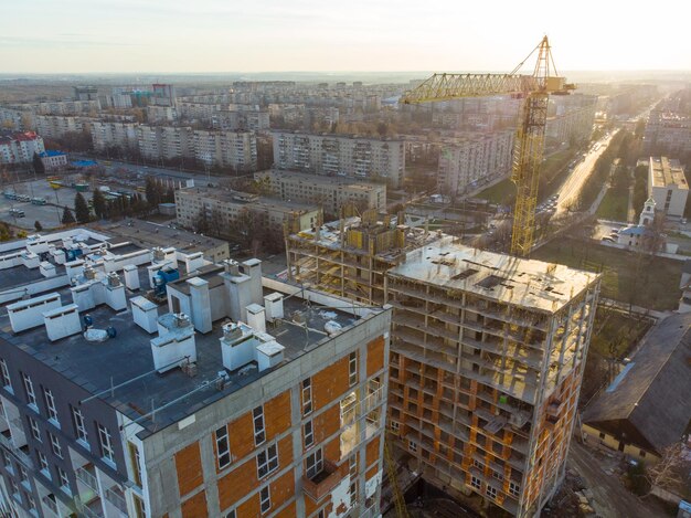 Birds eye view on contraction site with crane on sunset