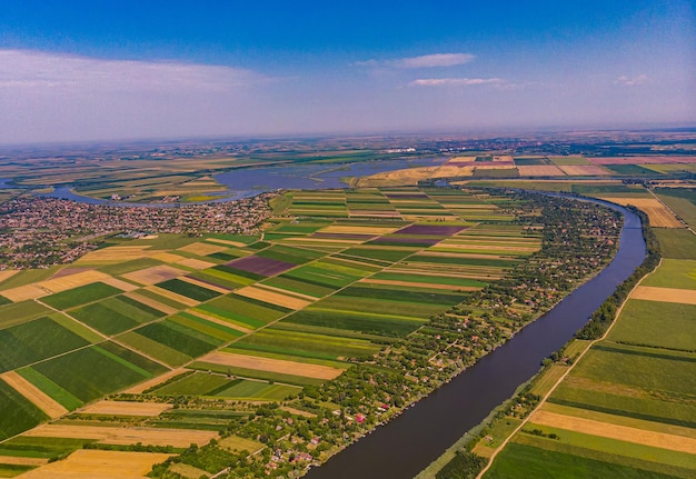 Вид с высоты птичьего полета на землю и протекающую через нее реку Тиса в Сербии.