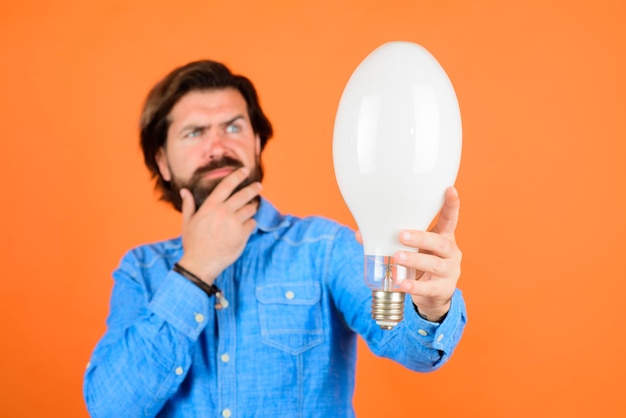 Birth of ideas thinking man with lamp idea good idea lightbulb\
in hand young man holds light bulb