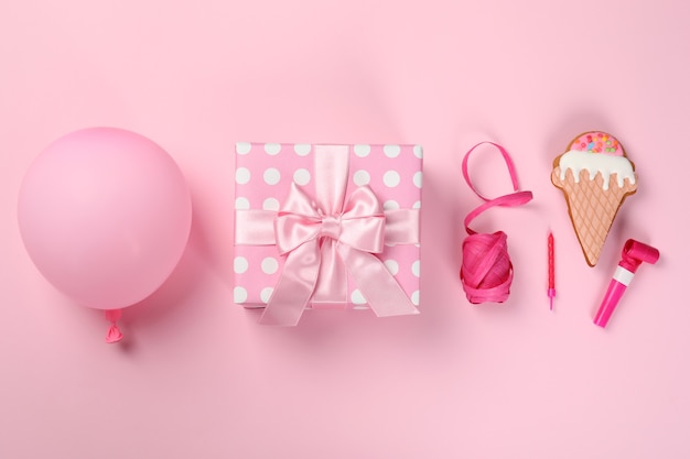 Birthday accessories on pink background, top view