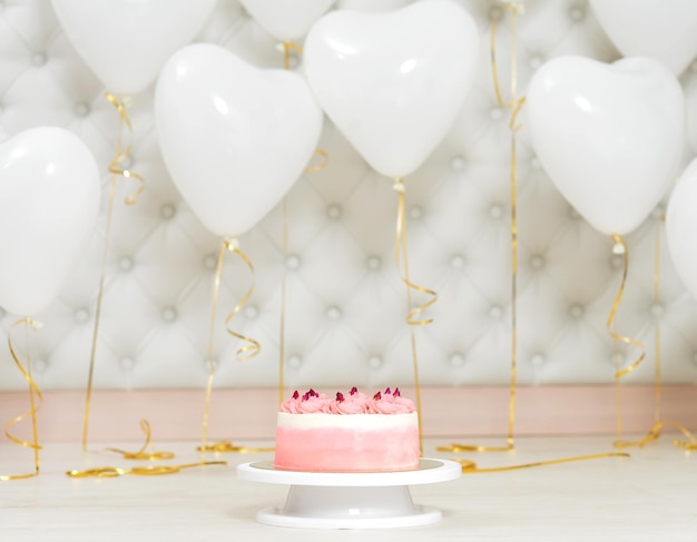 Birthday cake and hear shaped balloons close up