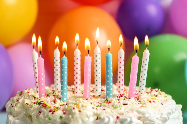 Foto torta di compleanno con le candele su sfondo di palloncini