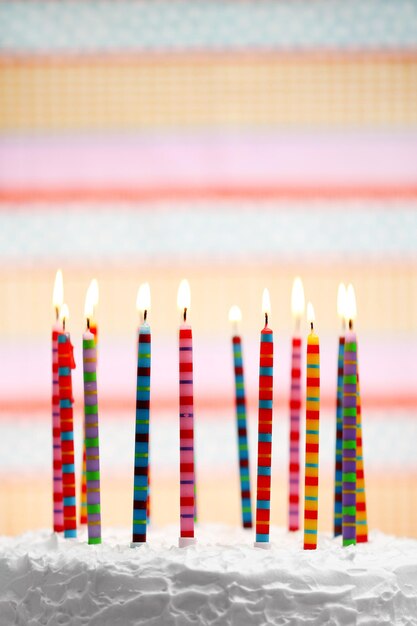 사진 다채로운 줄무 ⁇  배경에  ⁇ 불이 있는 생일 케이크