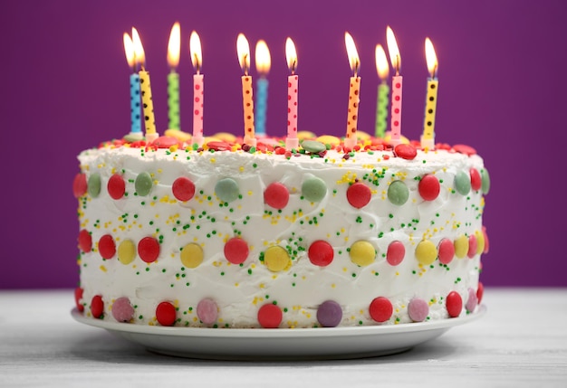보라색 배경에 촛불이 있는 생일 케이크