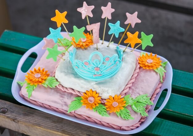Birthday cake with colorful flowers, stars and diadem