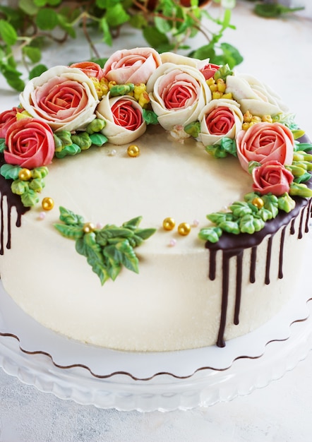 La torta di compleanno con i fiori è aumentato su bianco