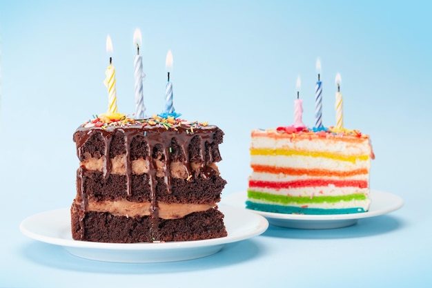 Birthday cakes with burning candles on a blue