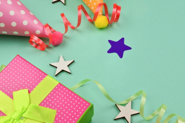 Шапки ко дню рождения и настоящее конфетти на зеленом фоне Пространство для текста или дизайна