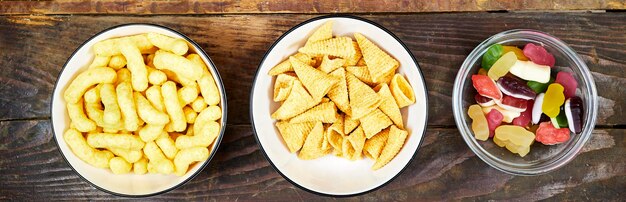 birthday or christmas new years party concept a bowls of different chips and candies on wooden ta