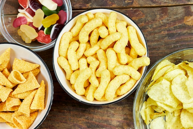 birthday or christmas new years party concept a bowls of different chips and candies on wooden ta