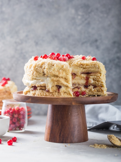 Napoleone torta di compleanno cremosa a strati o torta tritata. pasticcere decorato con frutti di bosco su una teglia, deliziosa dolcezza. il concetto di pasticceria fatta in casa, la cottura della torta.