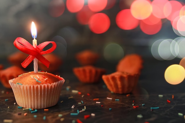 Birthday cupcake with a candle bokeh