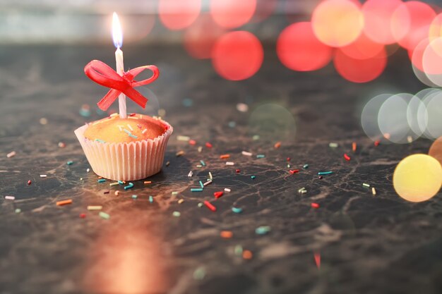 Birthday cupcake with a candle bokeh