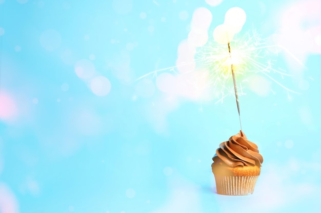 Photo birthday cupcake with sparkler on light blue background space for text
