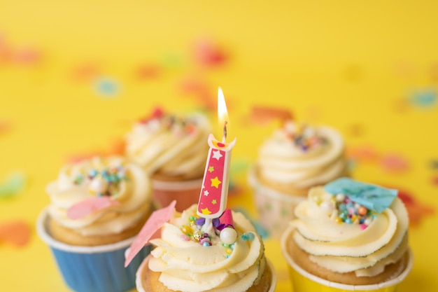 Birthday cupcakes in colorful colors on yellow background