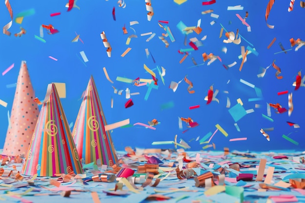 Birthday hat and confetti on blue background