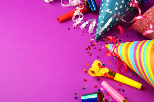 Birthday hats with serpentine streamer and noise makers on purple