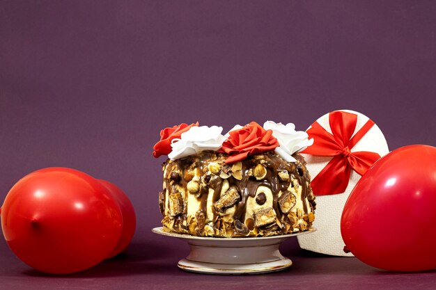 Birthday layer cake decorated with chocolate pieces and hazelnuts and almonds and happy birthday