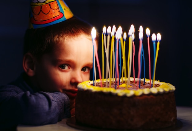 Birthday. A little boy blows out candles on the stoke.