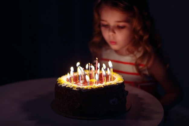 Compleanno. una bambina dolce spegne le candeline sullo stoke.