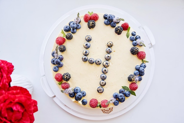 Birthday natural berries cake with figure 4 decorated with fresh raspberries blueberries mint on yellow cardamom background Child birthday39s cake