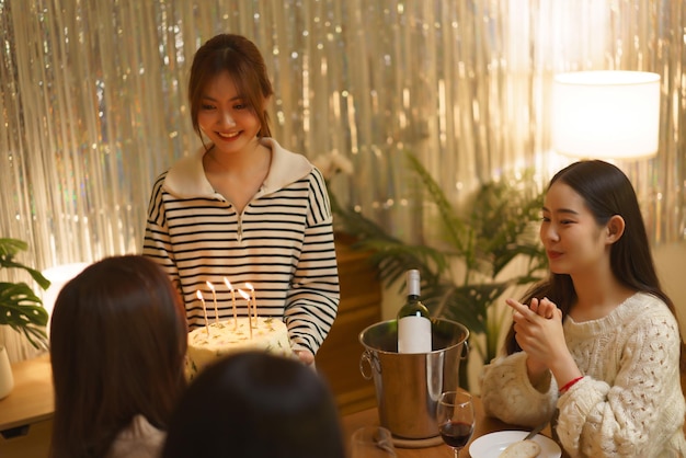 Birthday party concept Asian girls holding birthday cake with candles to surprise friend in party