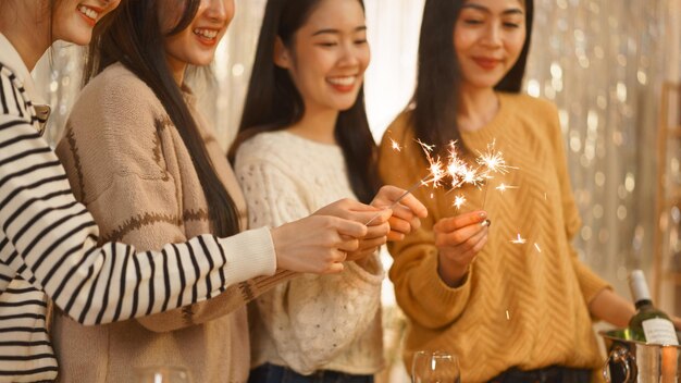 誕生日パーティーのコンセプト アジアの女の子が誕生日パーティーで夕食を祝いながら線香花火を演奏