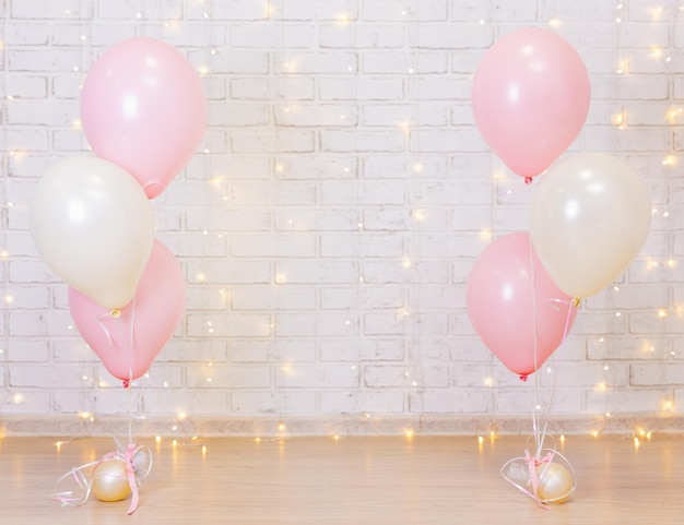 Photo birthday party concept - brick wall background with lights and pink balloons