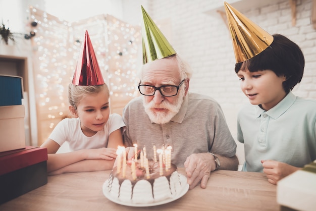 誕生日パーティー祖父は蝋燭を吹きます。