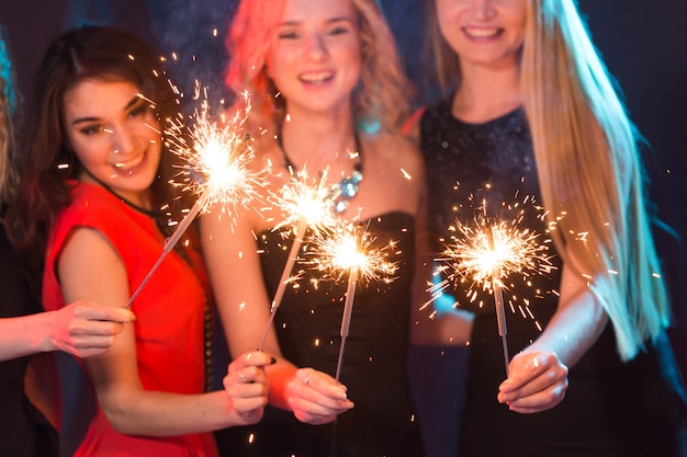 Birthday party, new year and holidays concept - Group of female friends celebrating holding sparklers close-up