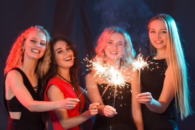 Birthday party, new year and holidays concept - Group of female friends celebrating holding sparklers.