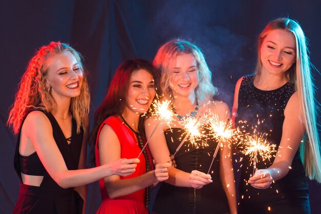 Birthday party, new year and holidays concept - Group of female friends celebrating holding sparklers.