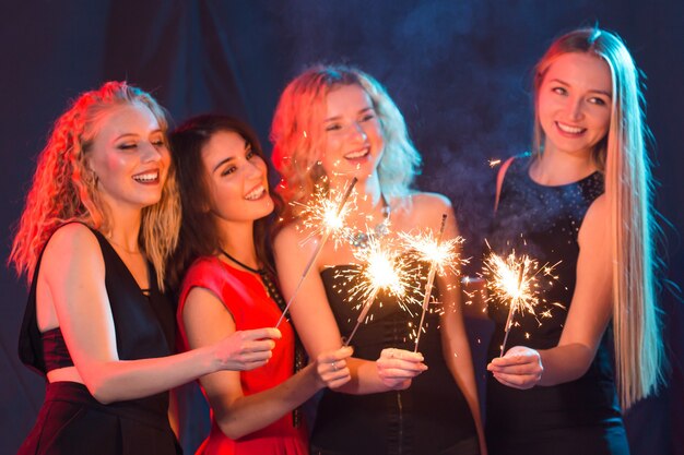 Birthday party, new year and holidays concept - Group of female friends celebrating holding sparklers.