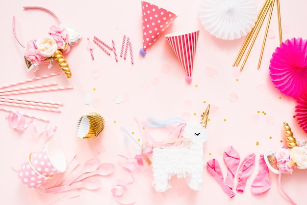 Photo birthday party in unicorn theme on pink flat lay.