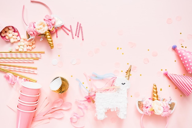 Birthday party in unicorn theme on pink flat lay.