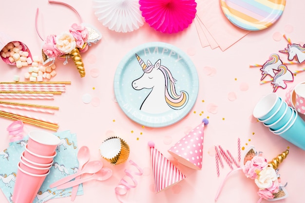 Photo birthday party in unicorn theme on pink flat lay.