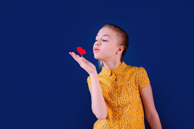 Birthday party and young girl in hats and props on blue wall