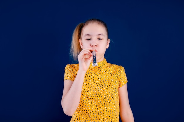 Birthday party and young girl in hats and props on blue wall