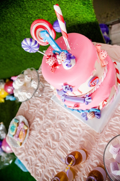 Birthday pink cake with candies and lolly-pops