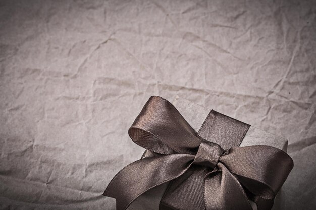 Birthday present box with bow on wrapping paper holidays concept