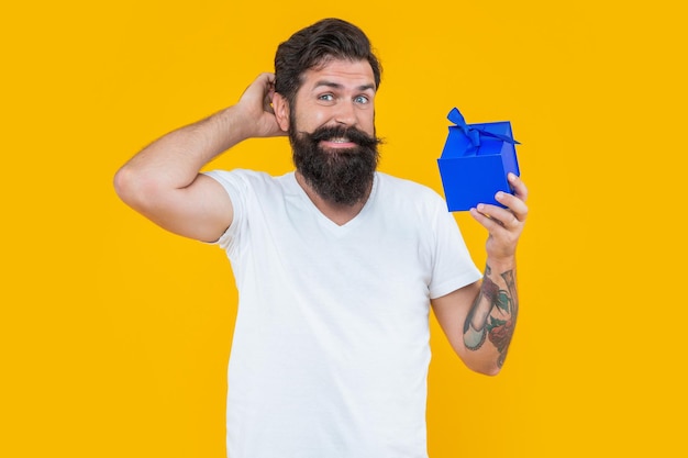 Birthday shopping of confused man isolated on yellow background man on birthday shopping bearded man go shopping for birthday man in studio with birthday gift shopping concept